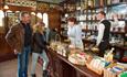 A couple talking to staff behind the counter of an old-fashioned sweetshop
