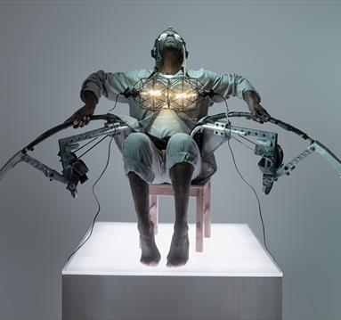 Benji Reid sat in a chair in a dystopian costume