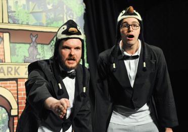 Two actors dressed as penguins