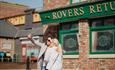 2 people posing for a photo outside of Rovers Return on the Coronation Street tour in Manchester