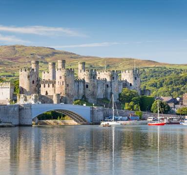 Conwy Castle with body of water and hills in the background