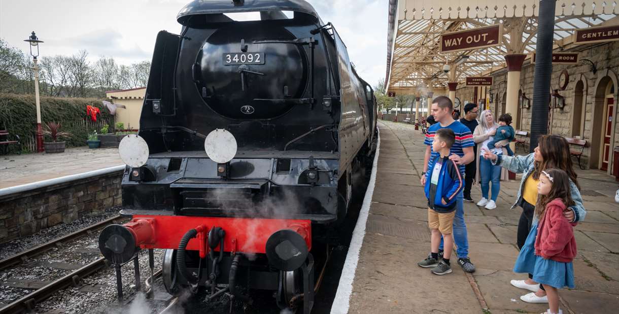Families on a platform with steam train