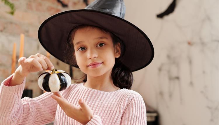 Girl Holding A Pumpkin Painted In Black And White