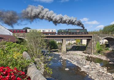 East Lancashire Railway train travelling over countryside bridge