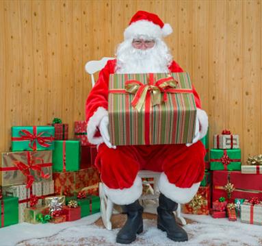 Father Christmas sitting surrounded by presents