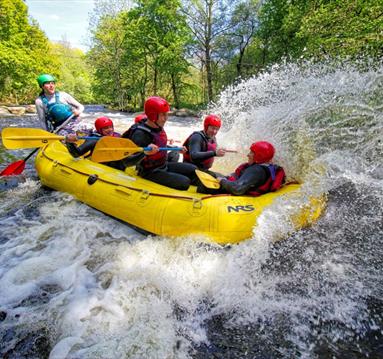 People on a raft, rafting down the white water river