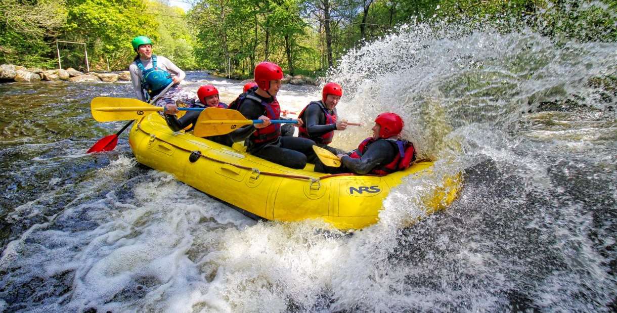 People on a raft, rafting down the white water river