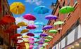 Colourful umbrellas floating above shoppers