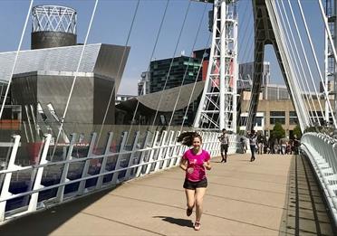 Woman in pink shirt running in Media City