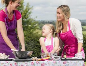 Cook teaching mother and daughter to bake