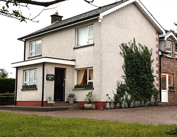 Image of a white two story house with climbing vines up the side