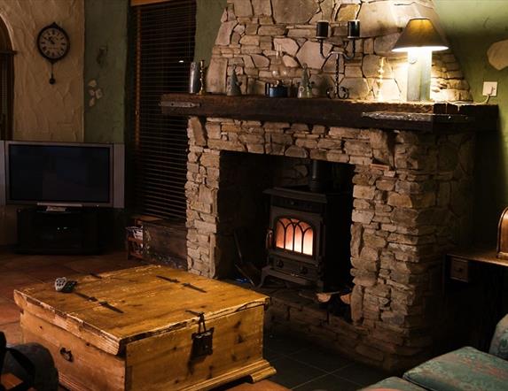 Cosy living room with stone fireplace and burner