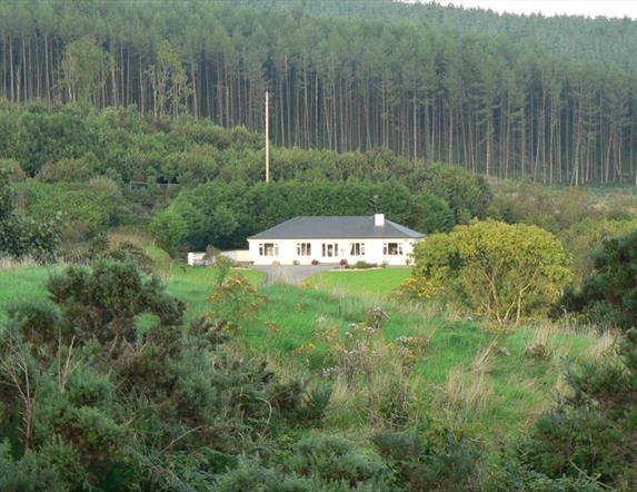 An image of a secluded house from across a field
