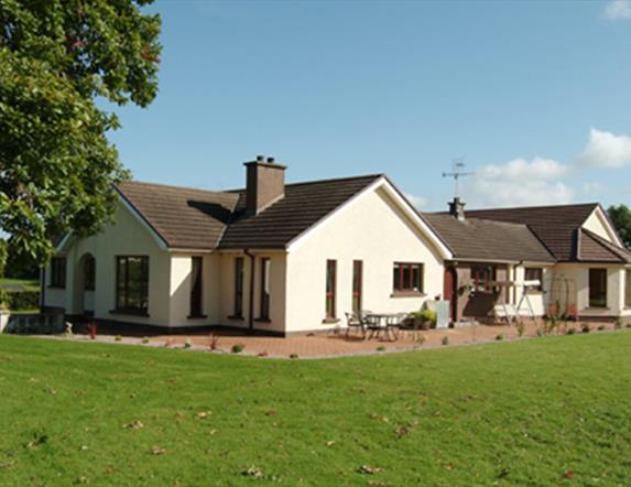 Outside view of house with patio area and large garden