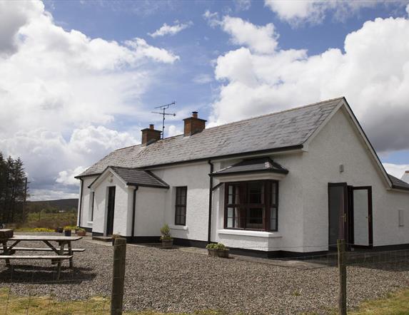 outside image of house with picnic table at front