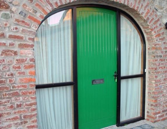 A green door in a arch way