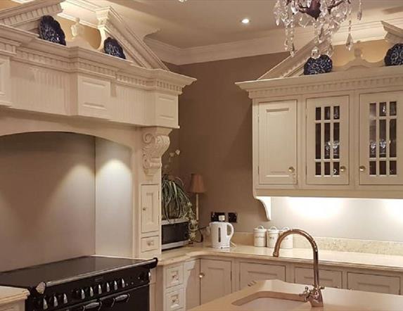 Modern Kitchen with range cooker, cream cabinets and sink in the island