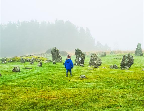 Young child on a misty morning walking through the Stone circles