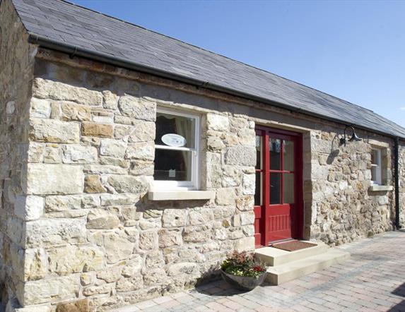 entrance to cottage with red door and stone walls