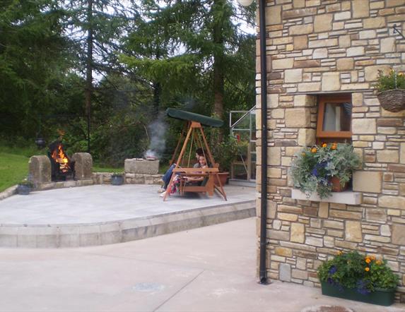 Outside patio area with firepit and wooden chair
