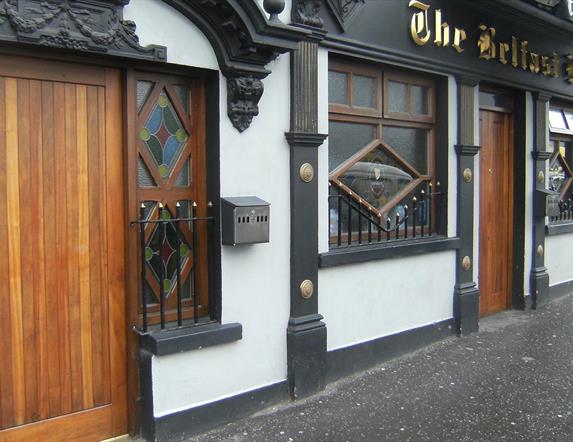 A white building with ornate black features and a wooden door