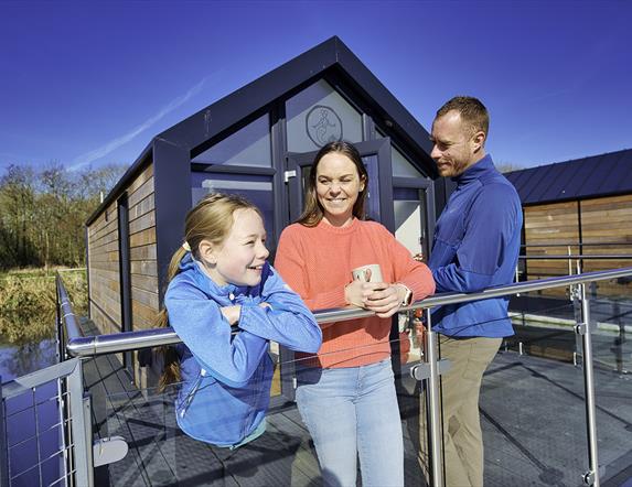 A family outside the house boat glamping pods at Ballyronan Marina