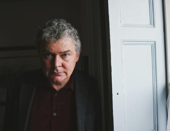 Image of John Spillane beside a white door