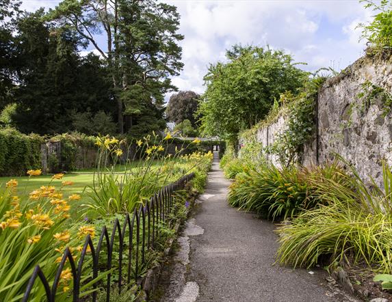 An image of a garden path at Springhill House surrounded by greenery