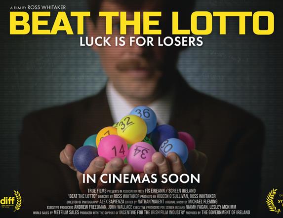 Image of gentleman in suit holding bright coloured lottery number balls
