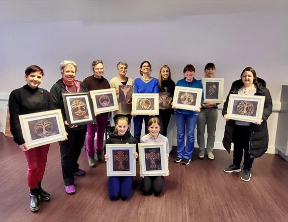 Image of a group of people holding up there copper crafts