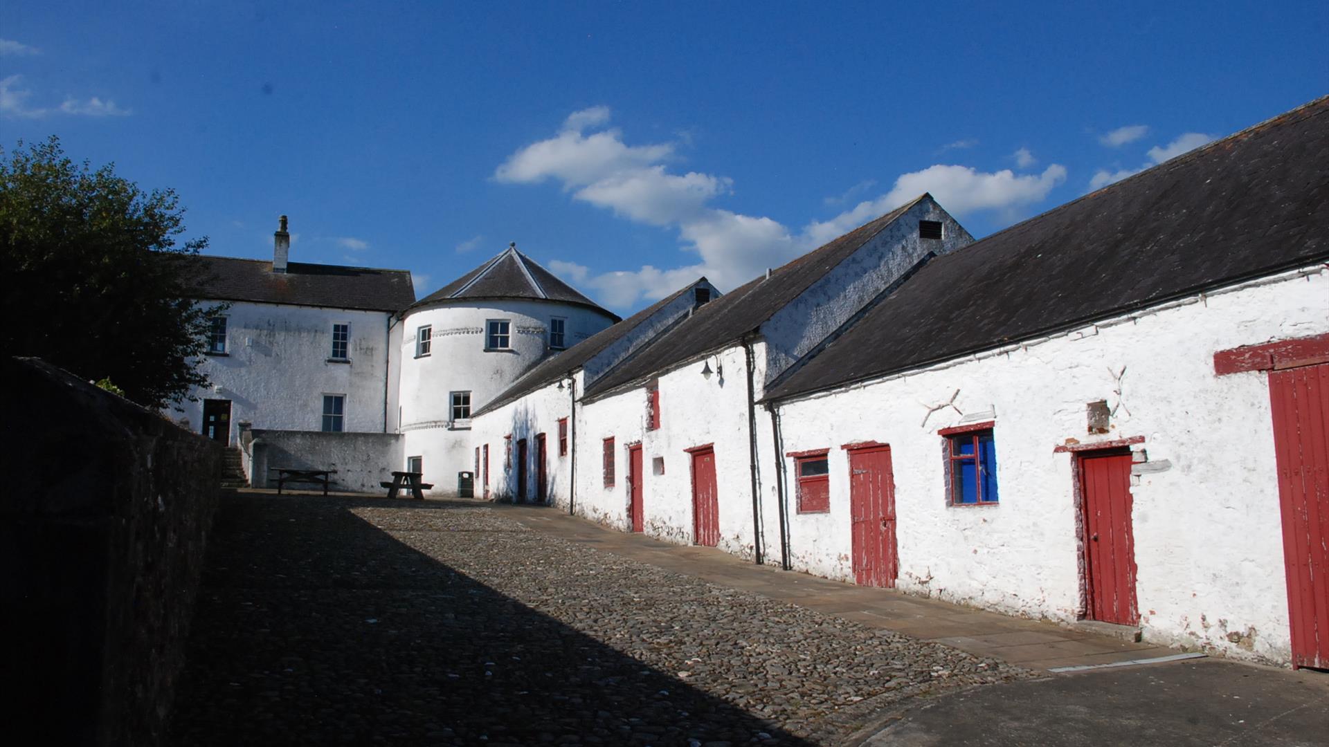 White stone washed walls with round tower type building in middle