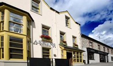 Outside image of The Tailor's house with yellow window frames and black door 