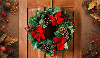Christmas wreath with fir tree branches, pinecones and red poinsettia. 