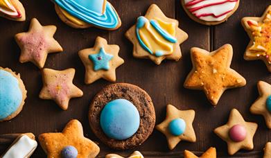A tray of brightly decorated cookies in the shape of stars and planets