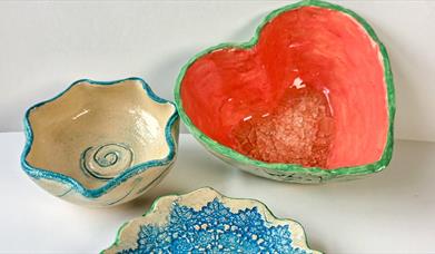 Photo showing 3 vessels of pottery shaped like a star, heart and flower.