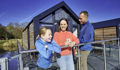 A family outside the house boat glamping pods at Ballyronan Marina 