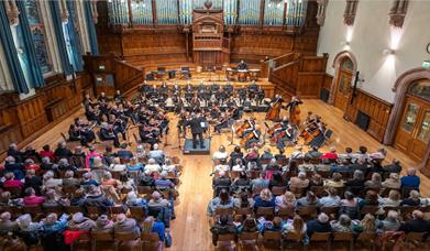Image of the orchestra playing in front of an audience