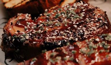 BBQ meat sprinkled with herbs and garlic bread slices