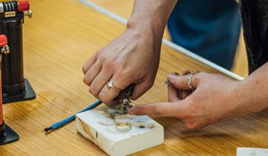 Person handcrafting a claddagh ring at Ranfurly House