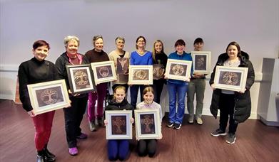 Image of a group of people holding up there copper crafts