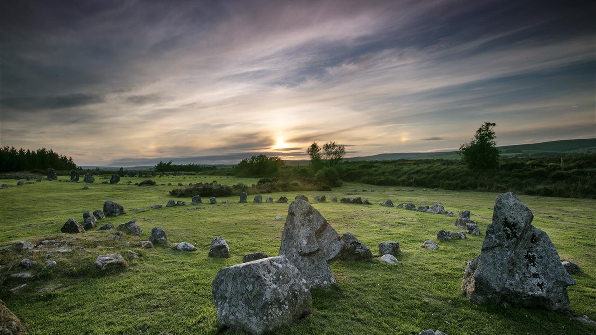 Image of the Beaghmore stone circle with the sun setting in the distance