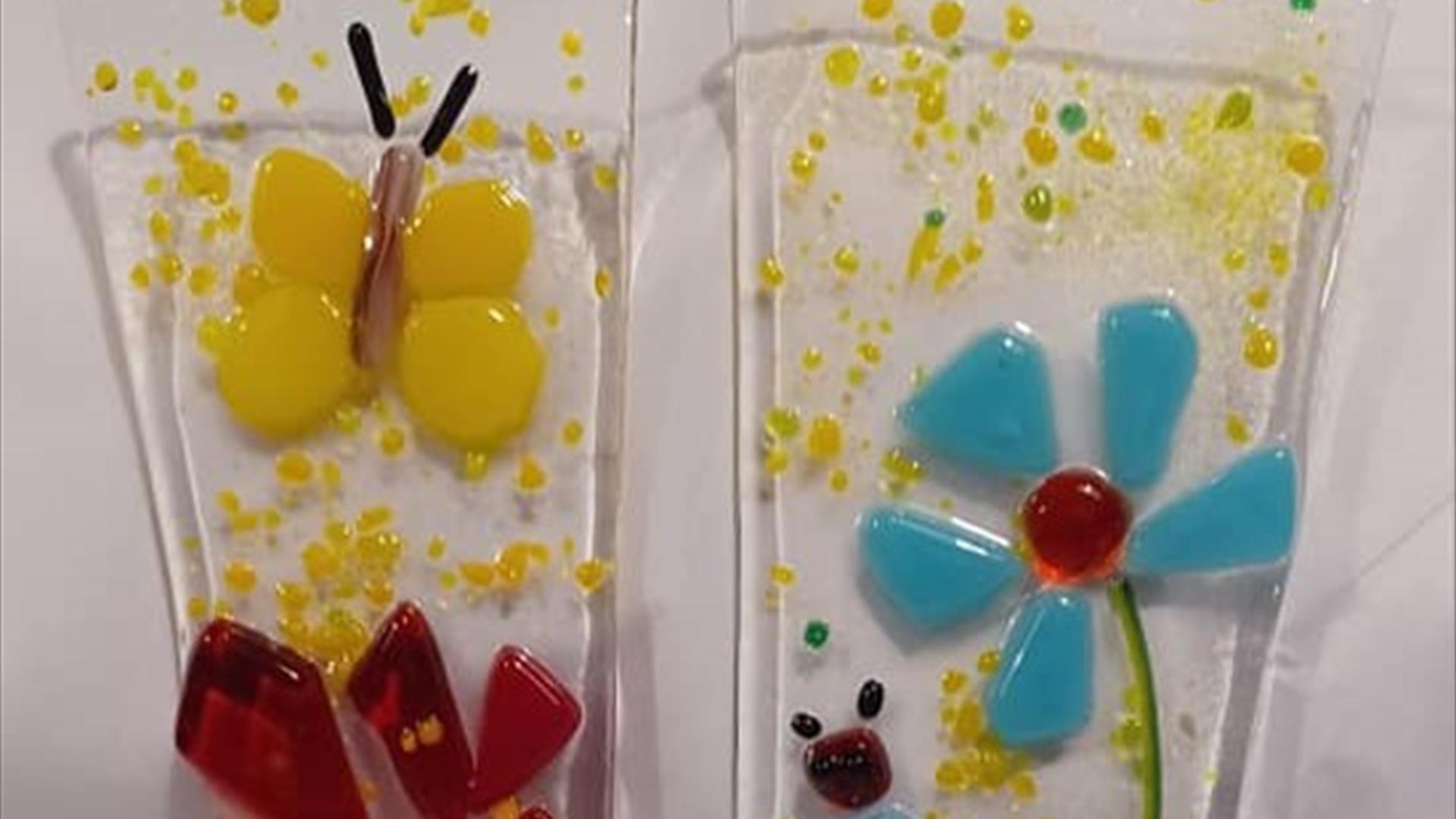 Glass plant pot stakes with colourful flowers on them