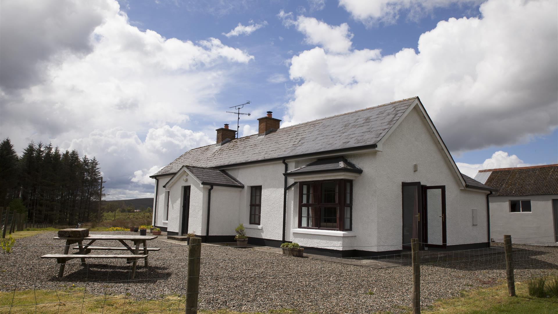 outside image of house with picnic table at front