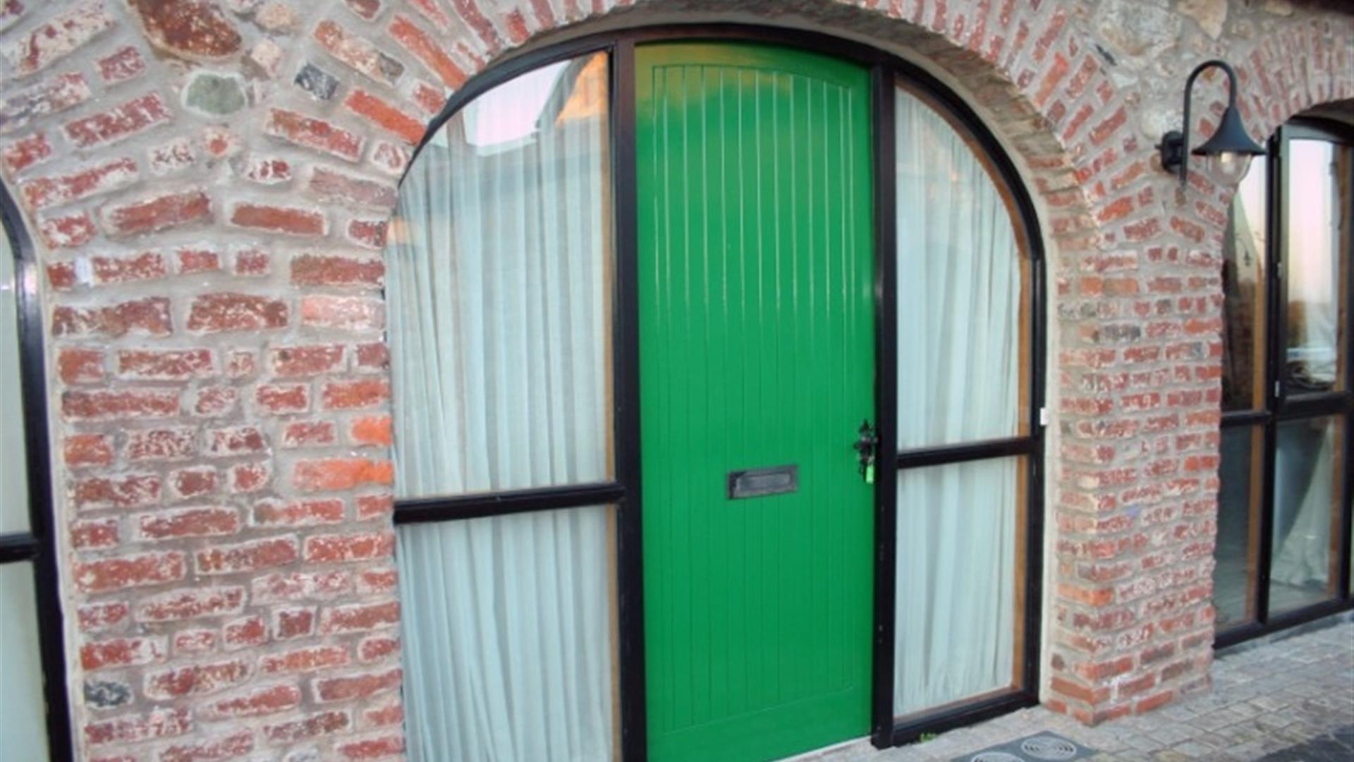 A green door in a arch way