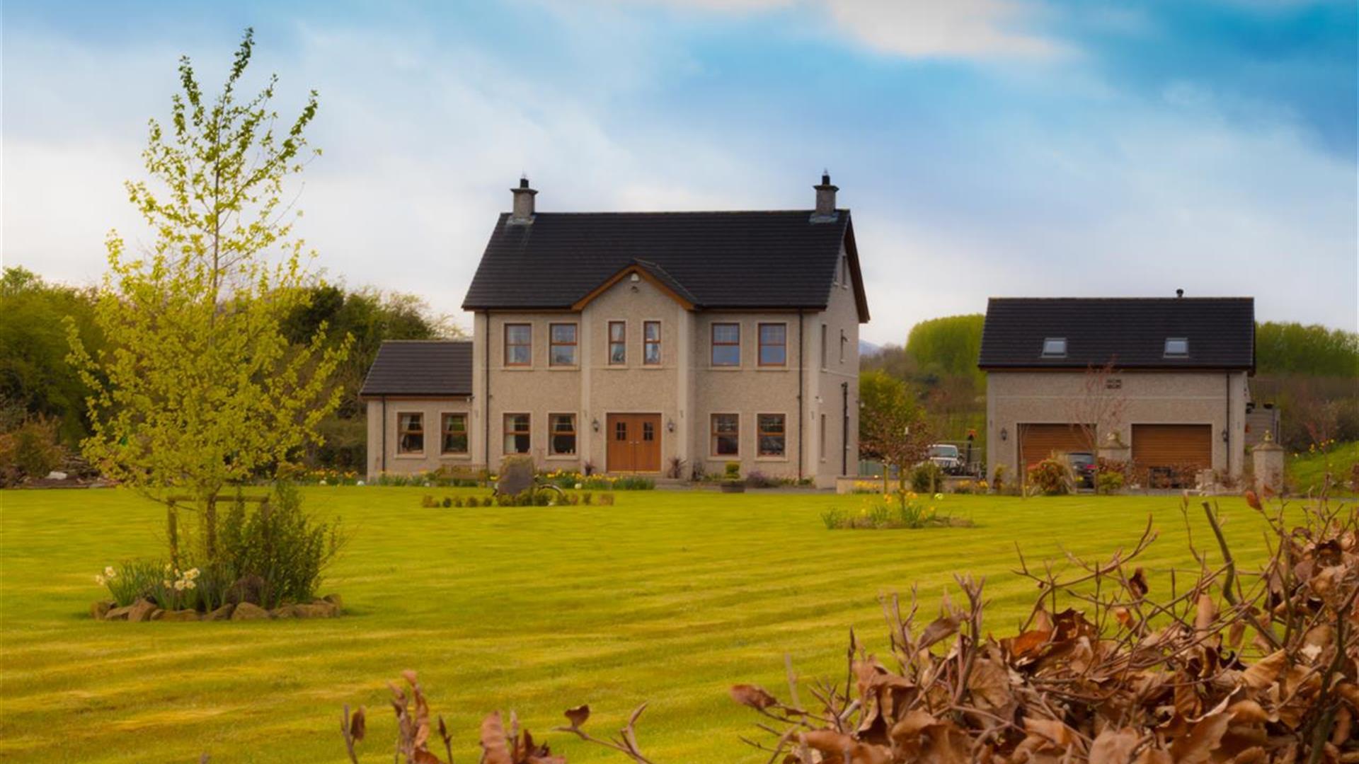Outside view of 2 storey house with double garage and large garden