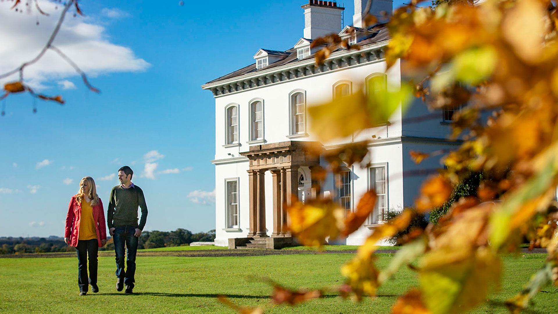 Image of couple walking with Ballyscullion house in the background