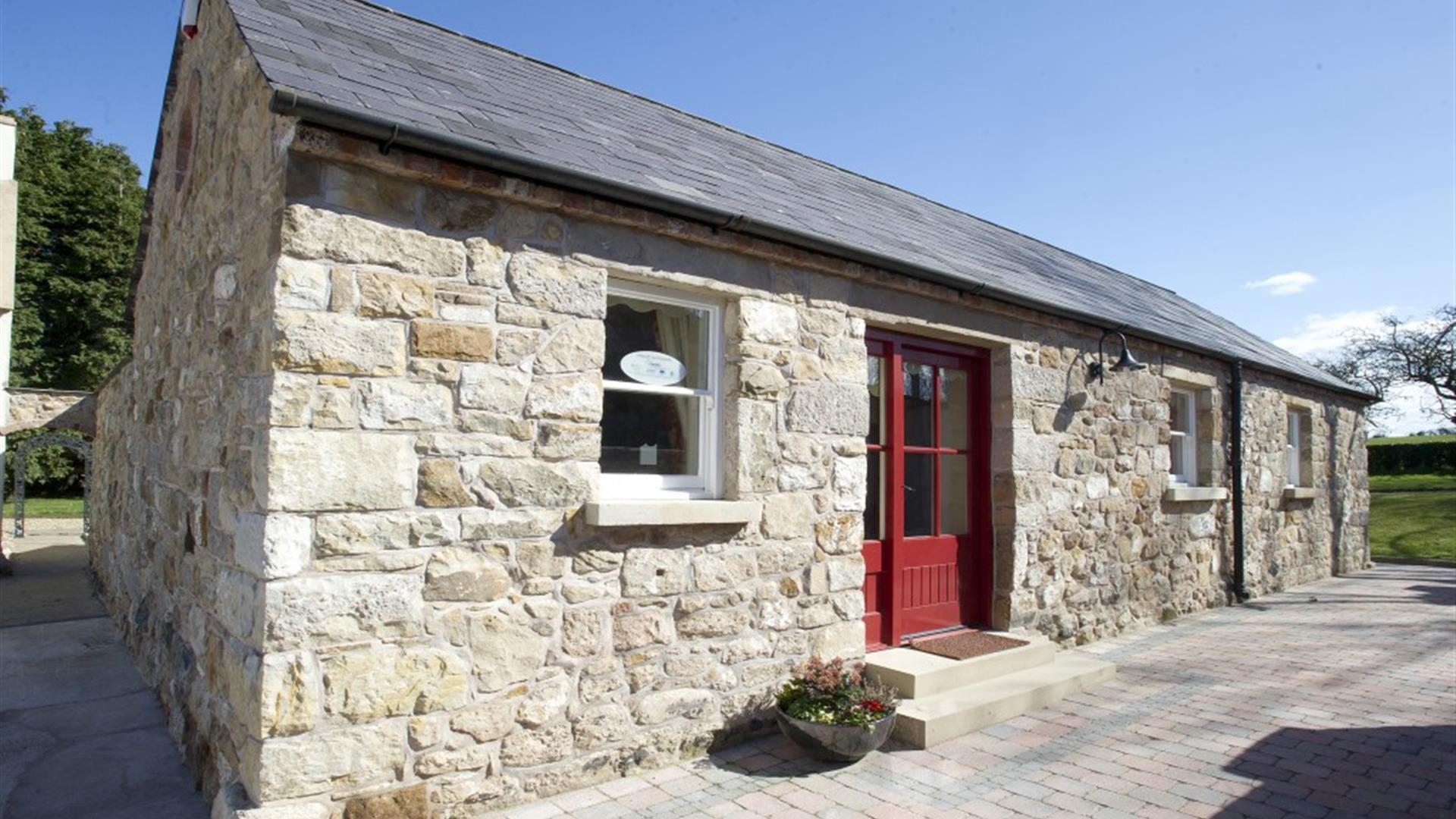 entrance to cottage with red door and stone walls