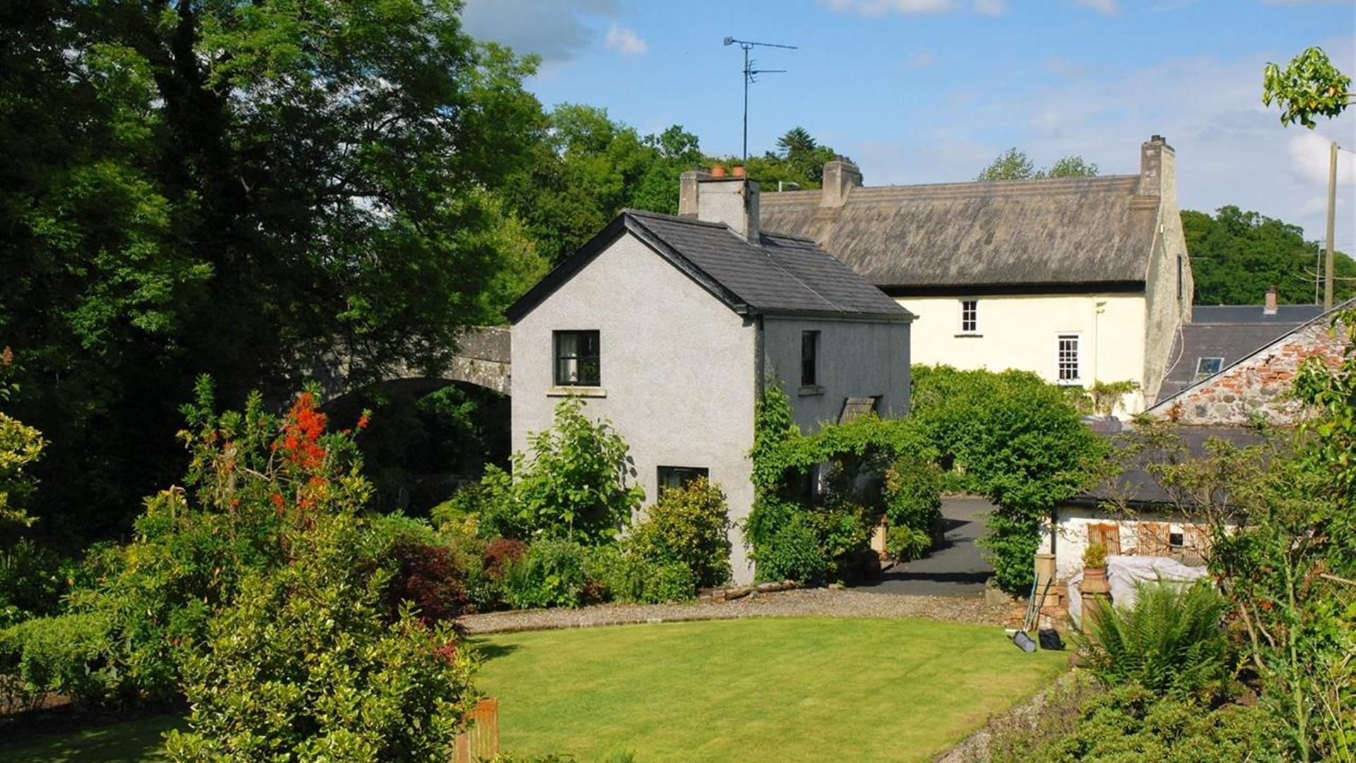 Bridge Cottage with surrounding grass and greenery