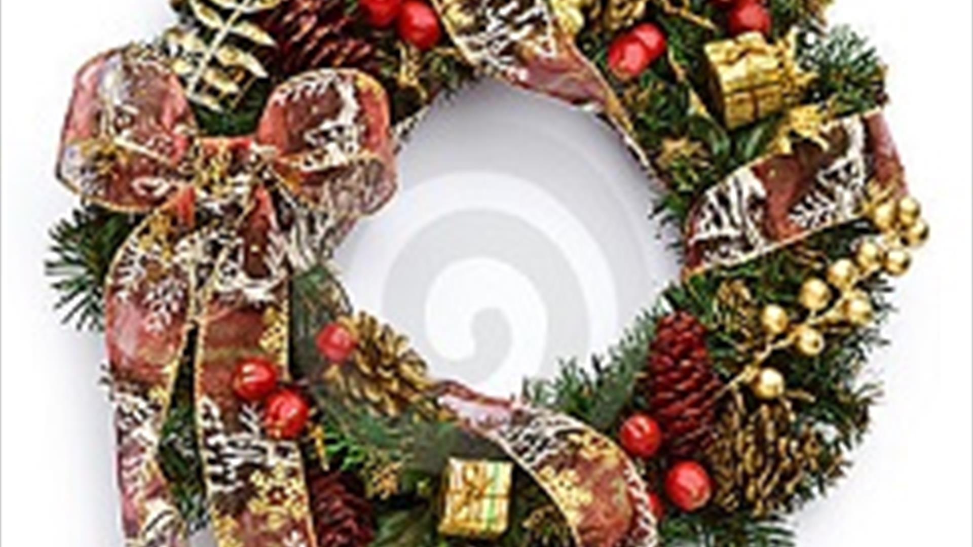 Image of a Christmas wreath with gold boxes, red bows and gold accessories.