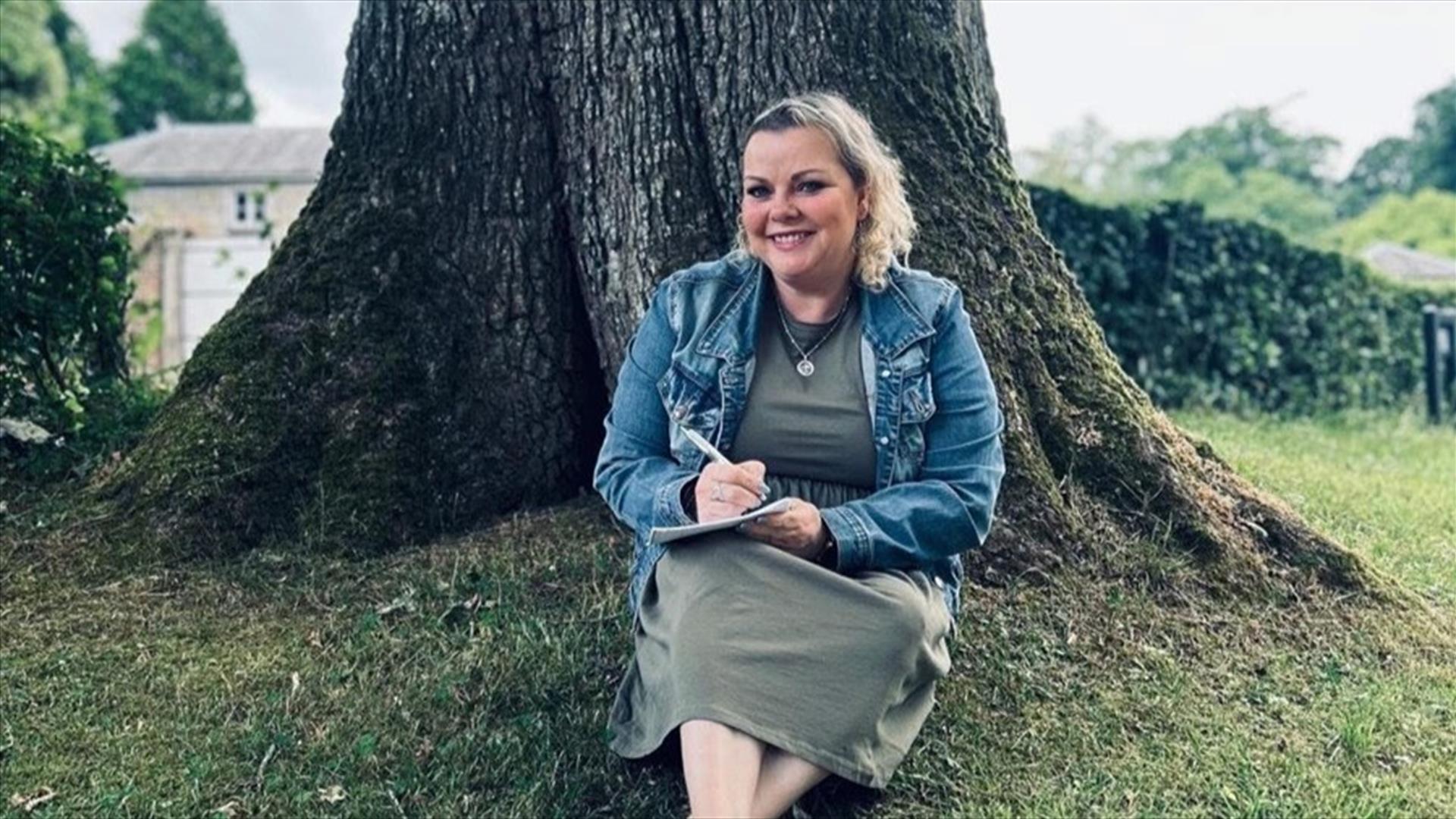 Fionnuala Cassidy sitting in front of a tree.